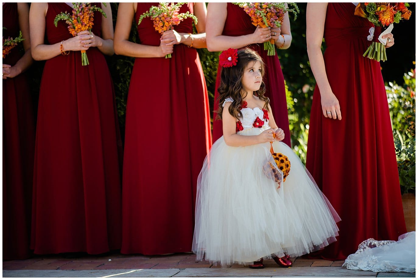 flower girl with red flower accents at Denver Botanic Gardens wedding by Denver wedding photographer Jennie Crate