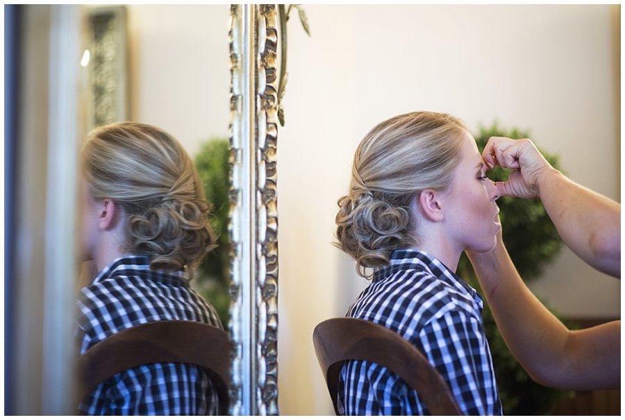 bride getting make up done at Deer Creek Valley Ranch wedding by Colorado wedding photographer Jennie Crate
