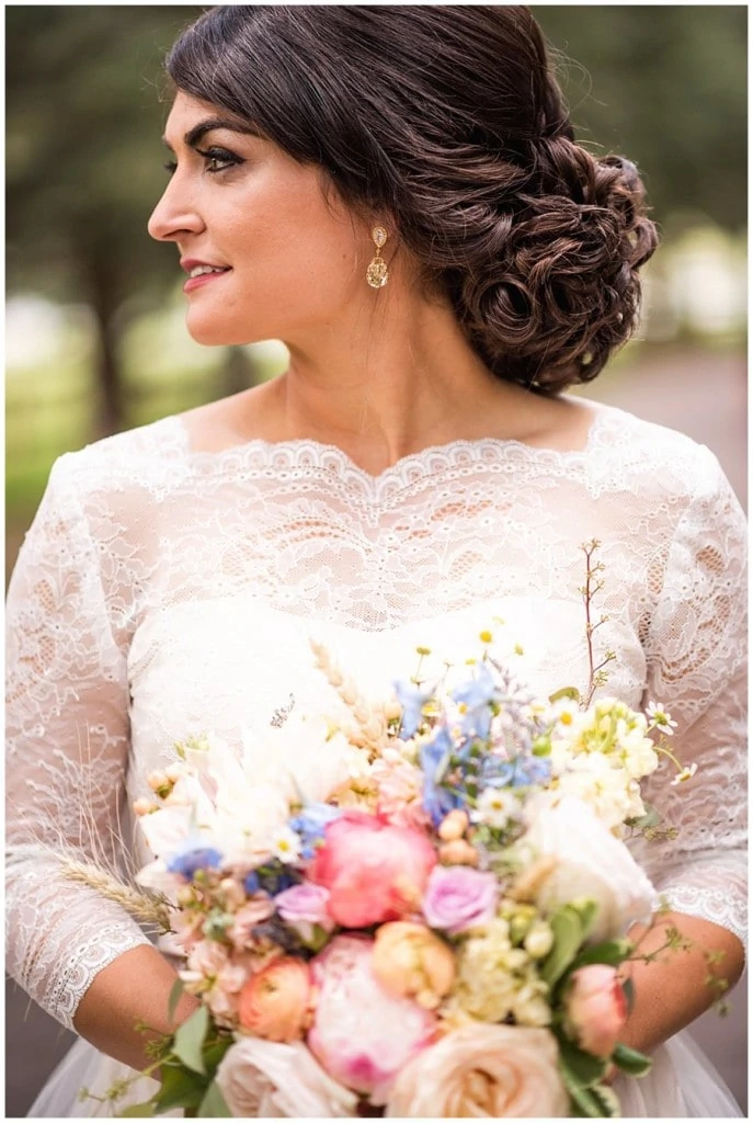bride with long sleeved lace wedding dress and gorgeous updo at Deer Creek Valley Ranch wedding by Boulder wedding photographer Jennie Crate