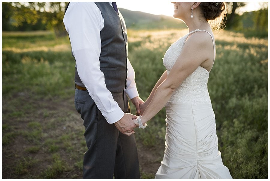 bride and groom hold hands at sunset in fields at spring Denver Botanic Gardens at Chatfield Wedding by Lyons wedding photographer Jennie Crate