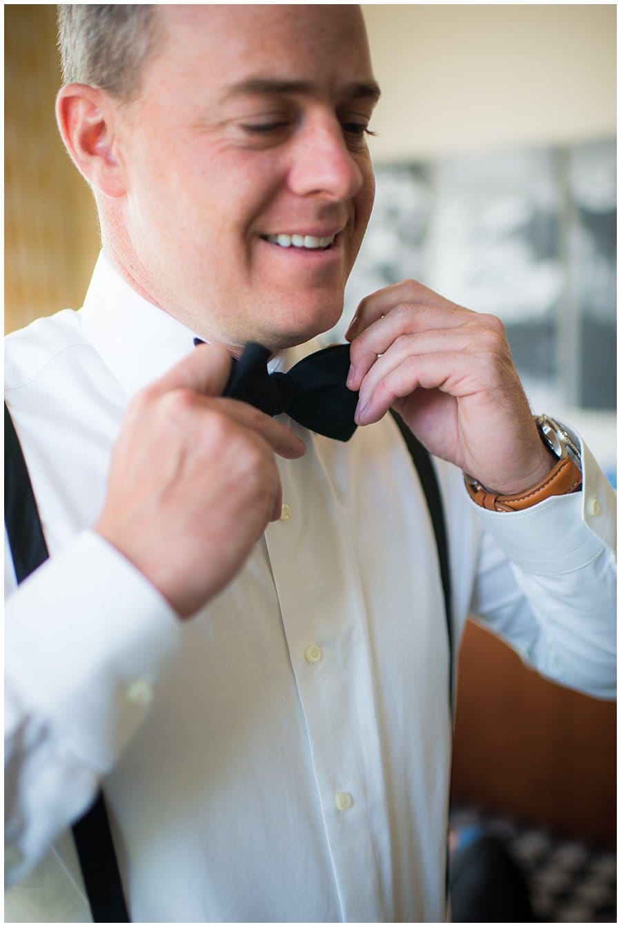 groom tying bow tie before wedding at blanc Denver wedding by Denver Wedding Photographer Jennie Crate Photographer