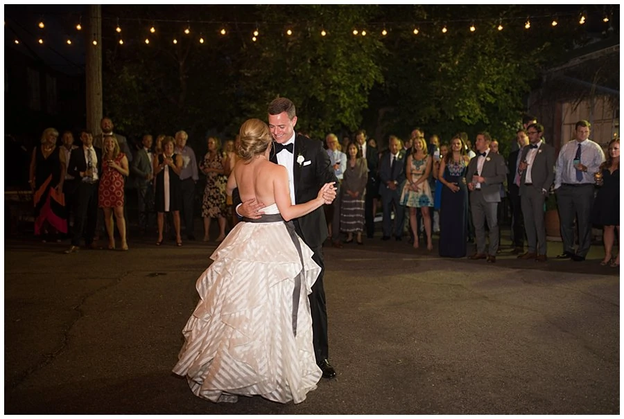 bride and groom first dance under market lights on the patio at blanc Denver wedding by Blanc Wedding Photographer Jennie Crate Photographer