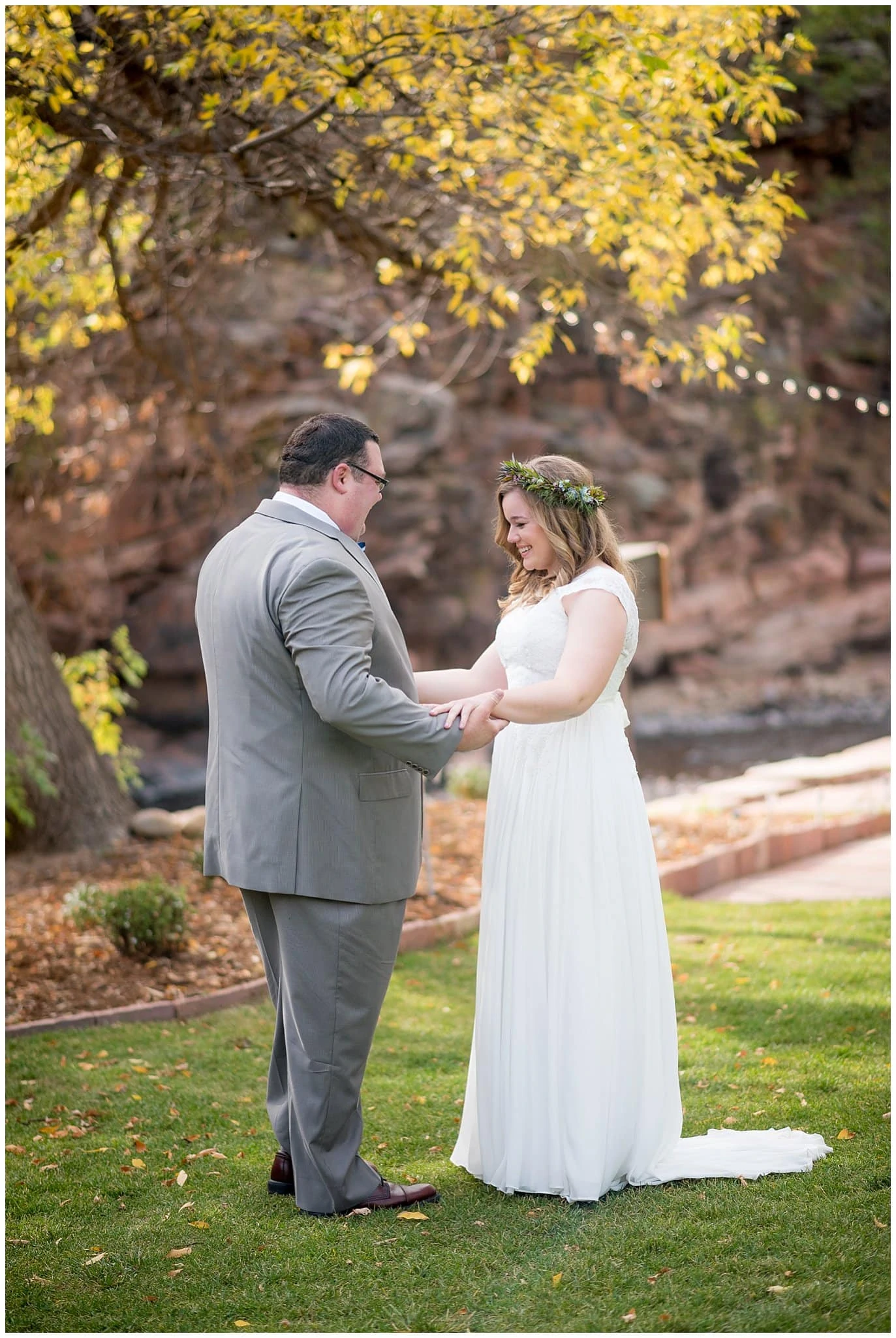 bride and groom first look under fall trees at Lyons Riverbend wedding by Lyons wedding photographer Jennie Crate