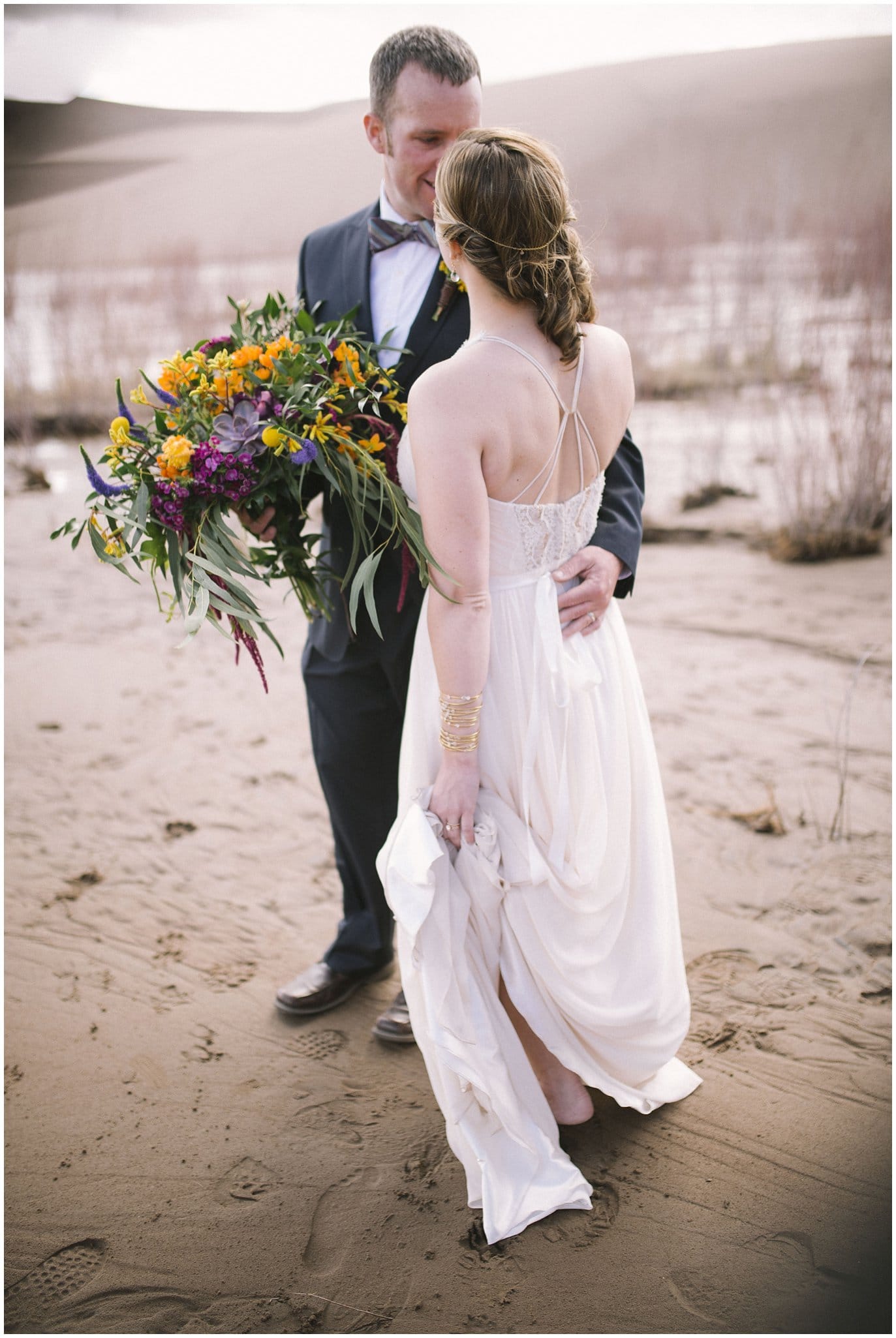 couple barefoot in sand dunes colorado wedding photo