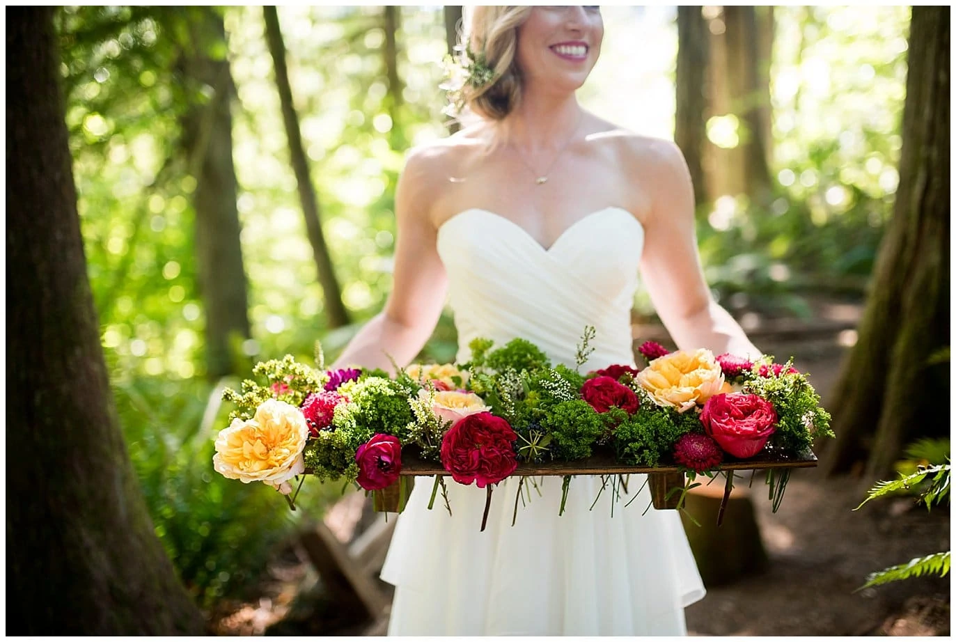 bride holding floral centerpiece for woodland elopement photo