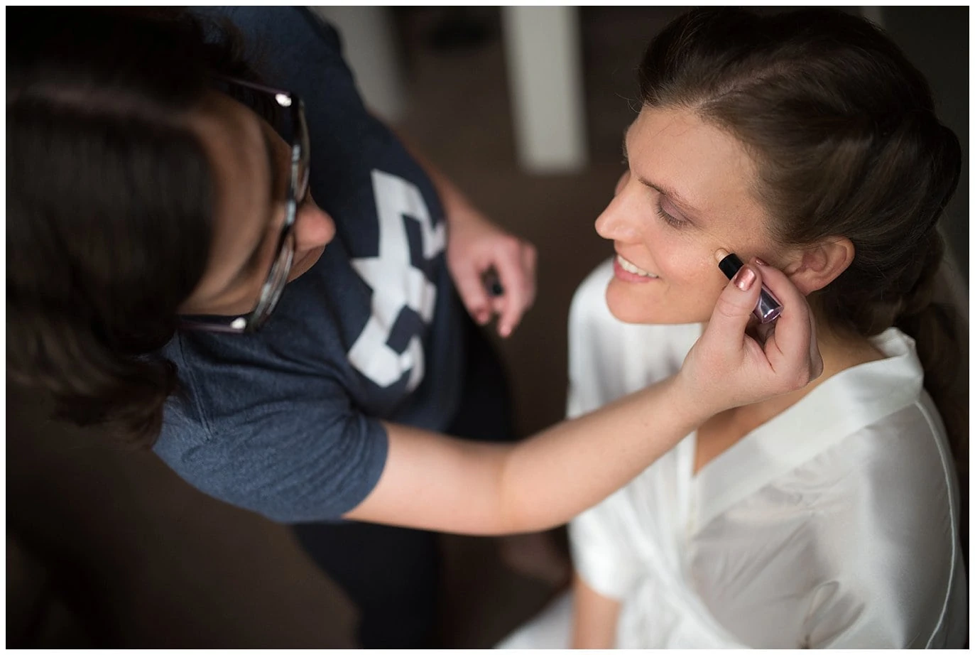 bride getting make up done on wedding day photo