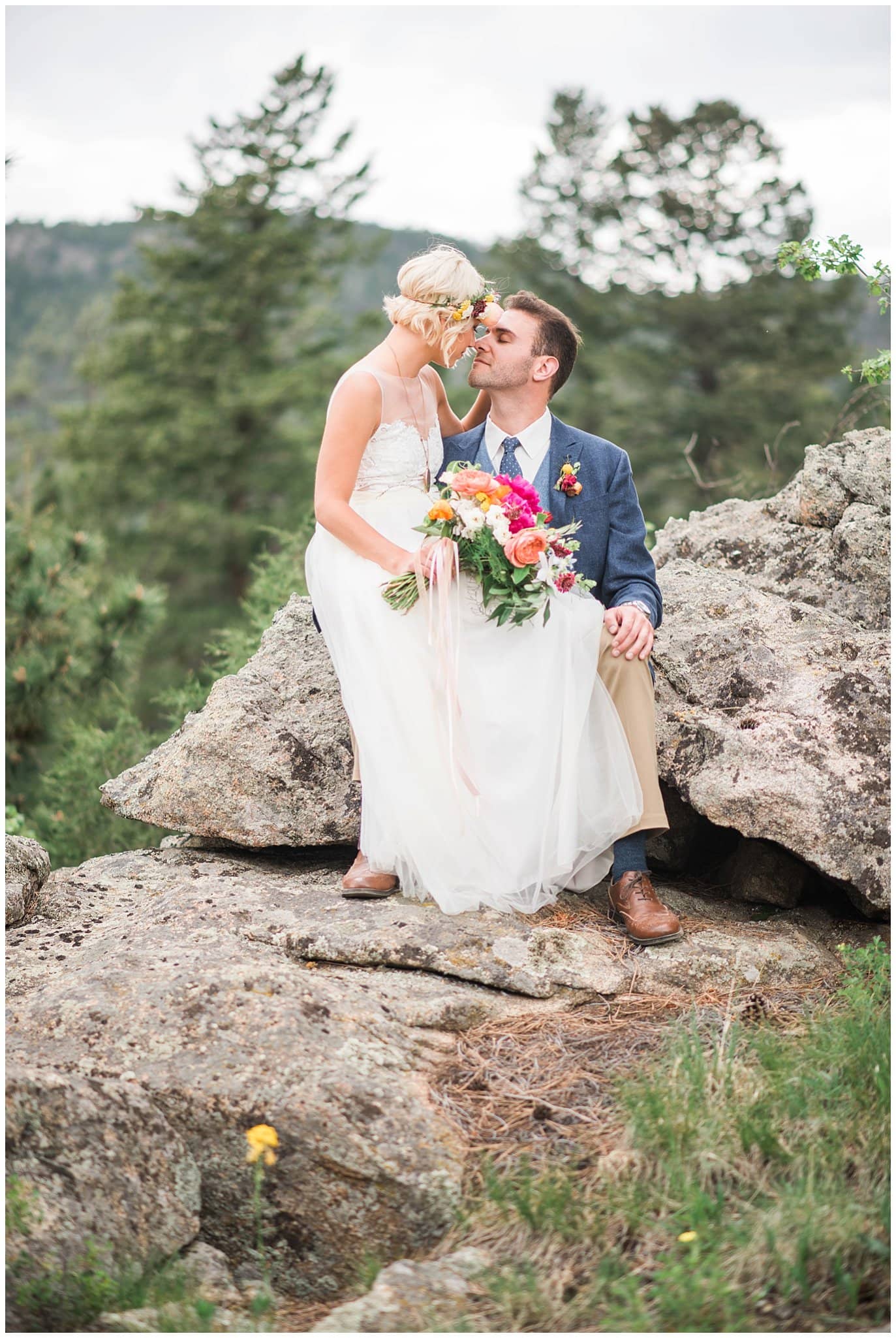 couple on rocks with colorful flowers photo