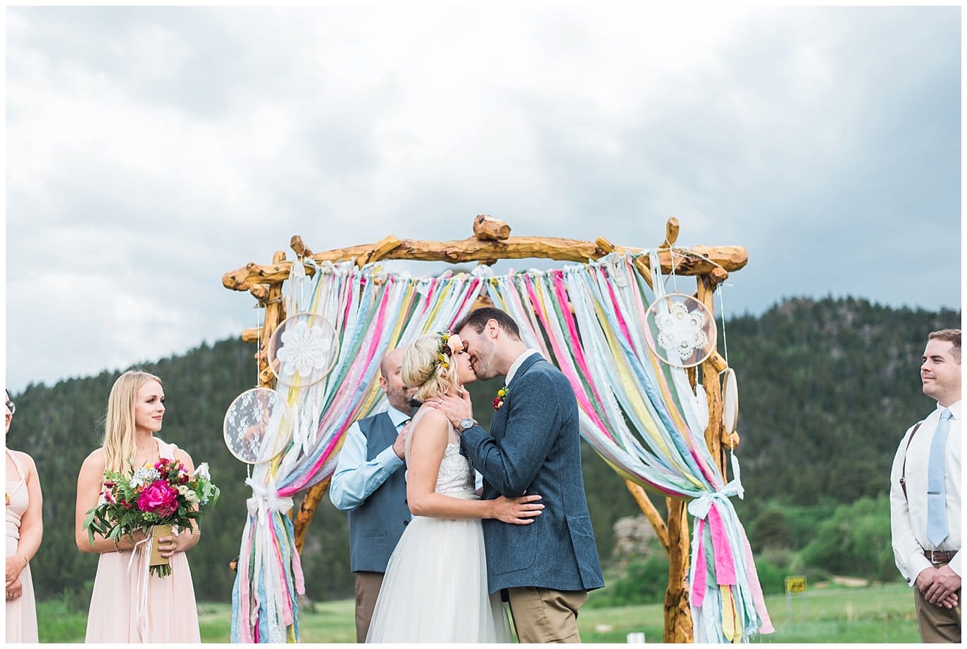 first kiss in front of colorful streamer arch photo