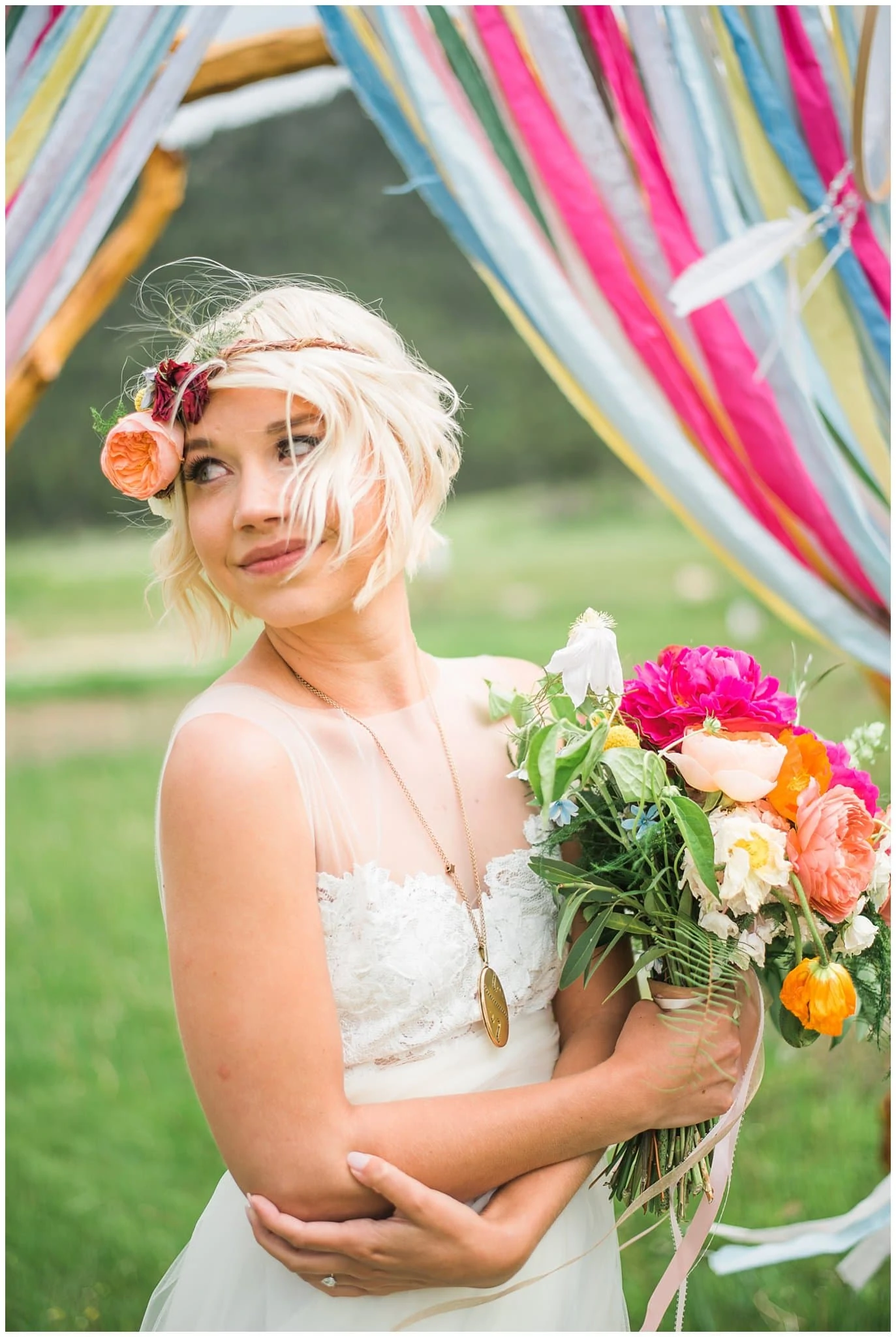 bride in front of colorful wedding arch photo