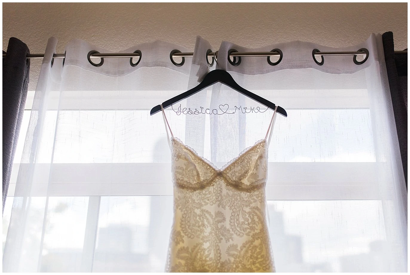 lace wedding dress hanging in window photo
