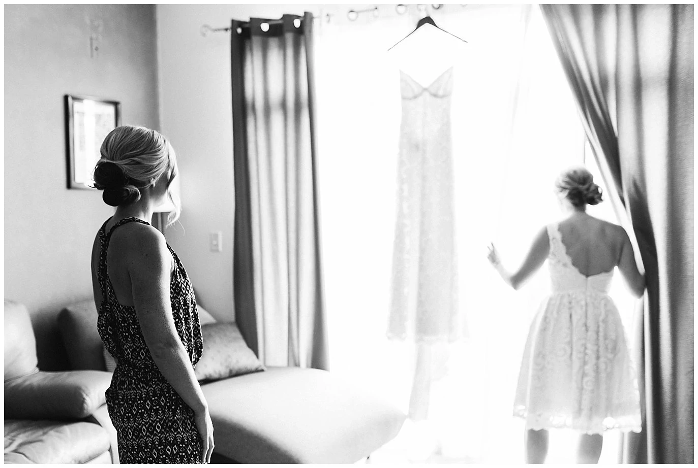 bride looking at lace wedding dress in window photo