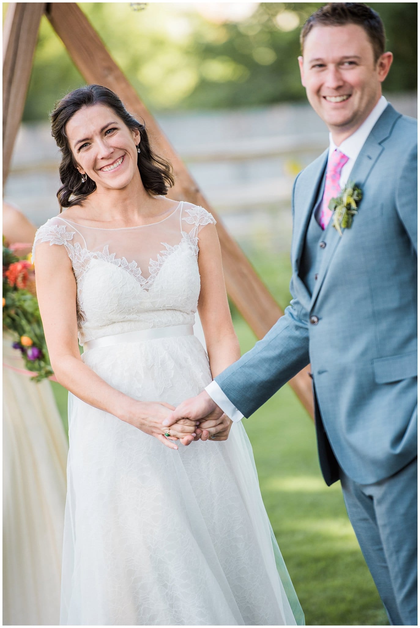Bride and groom smiling during ceremony at Lyons Farmette wedding by Loveland Wedding Photographer Jennie Crate