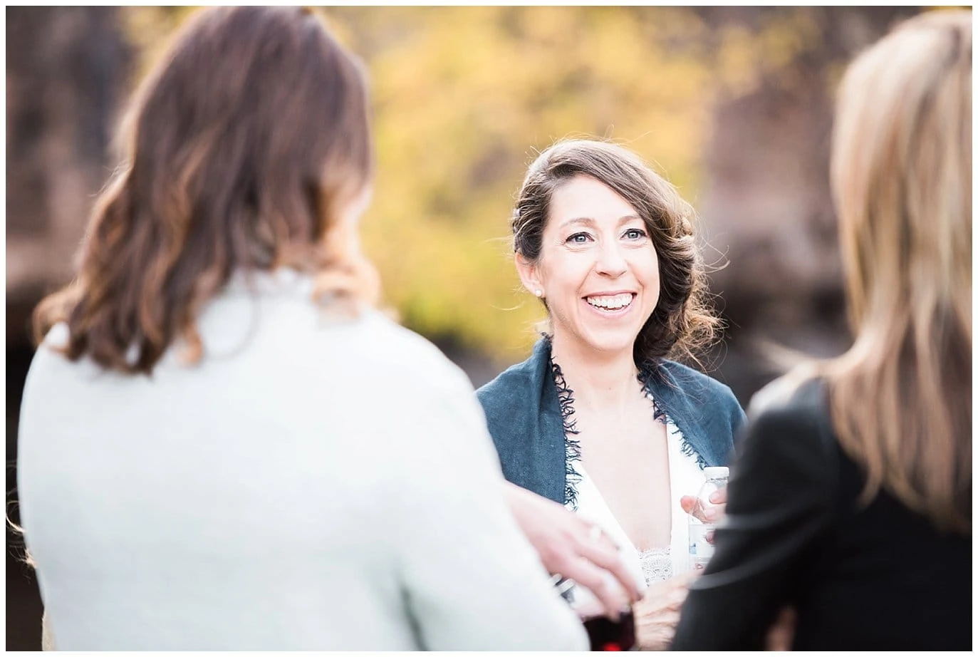 bride smiling during cocktail hour at Lyons Riverbend Wedding by Colorado Wedding Photographer Jennie Crate