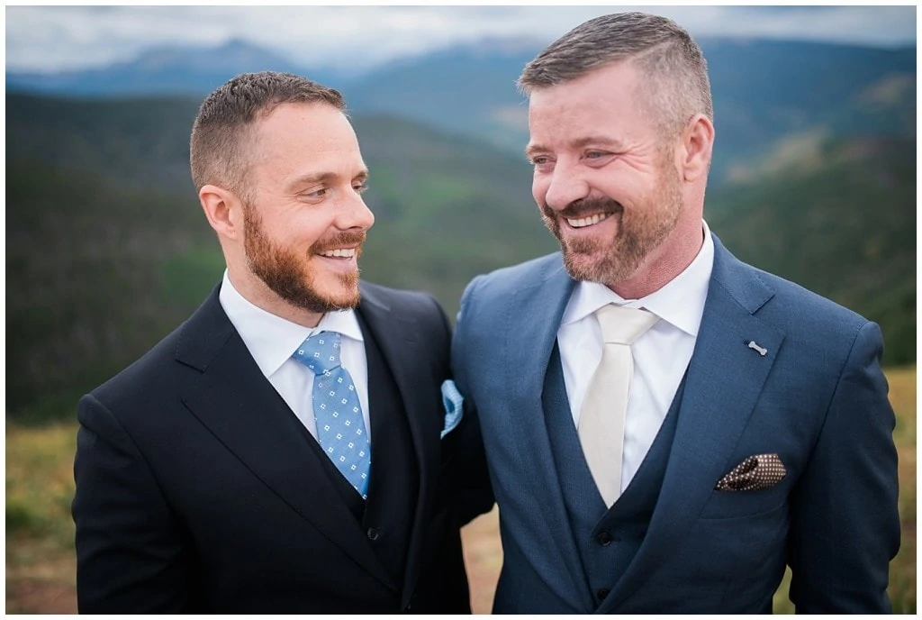two grooms after ceremony at top of Vail Mountain Wedding Deck by Colorado Gay Wedding Photographer Jennie Crate Photographer
