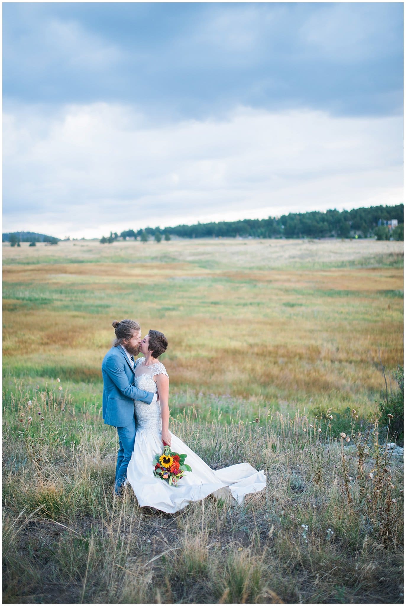 bride and groom kissing in colorful field