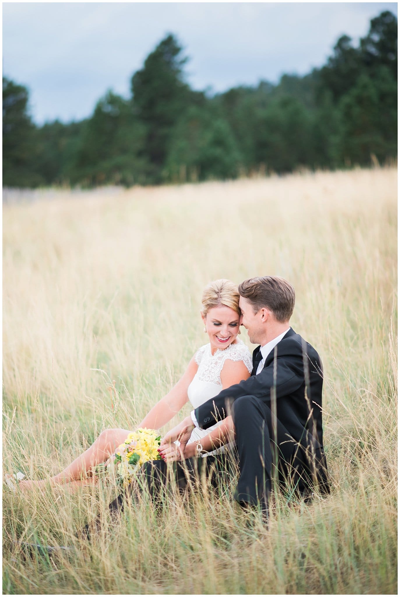 couple snuggling in Colorado field on wedding day