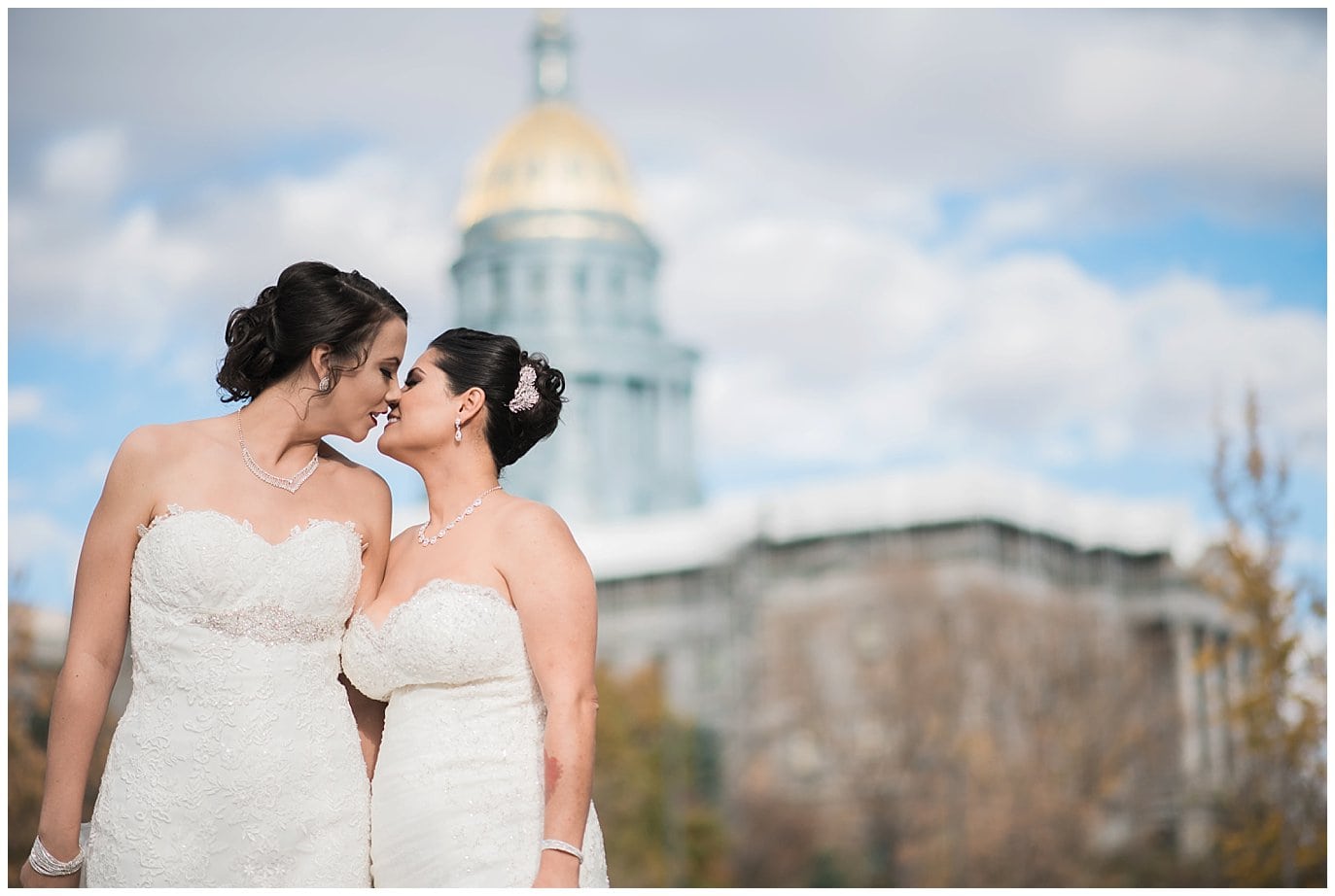brides kissing in front of Denver capital photo