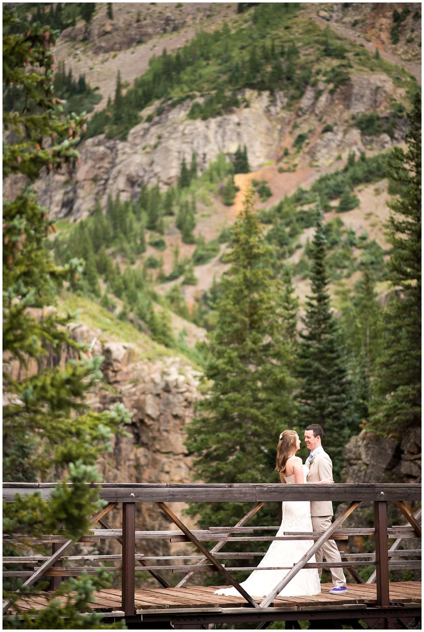 bride and groom on mountain bridge at Eureka Lodge Wedding by Colorado Wedding Photographer Jennie Crate