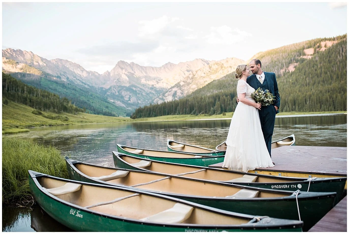 bride and groom on dock by canoes at Piney River Ranch wedding by Aspen wedding photographer Jennie Crate photographer