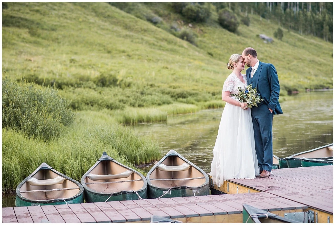 couple kissing on dock with canoes photo