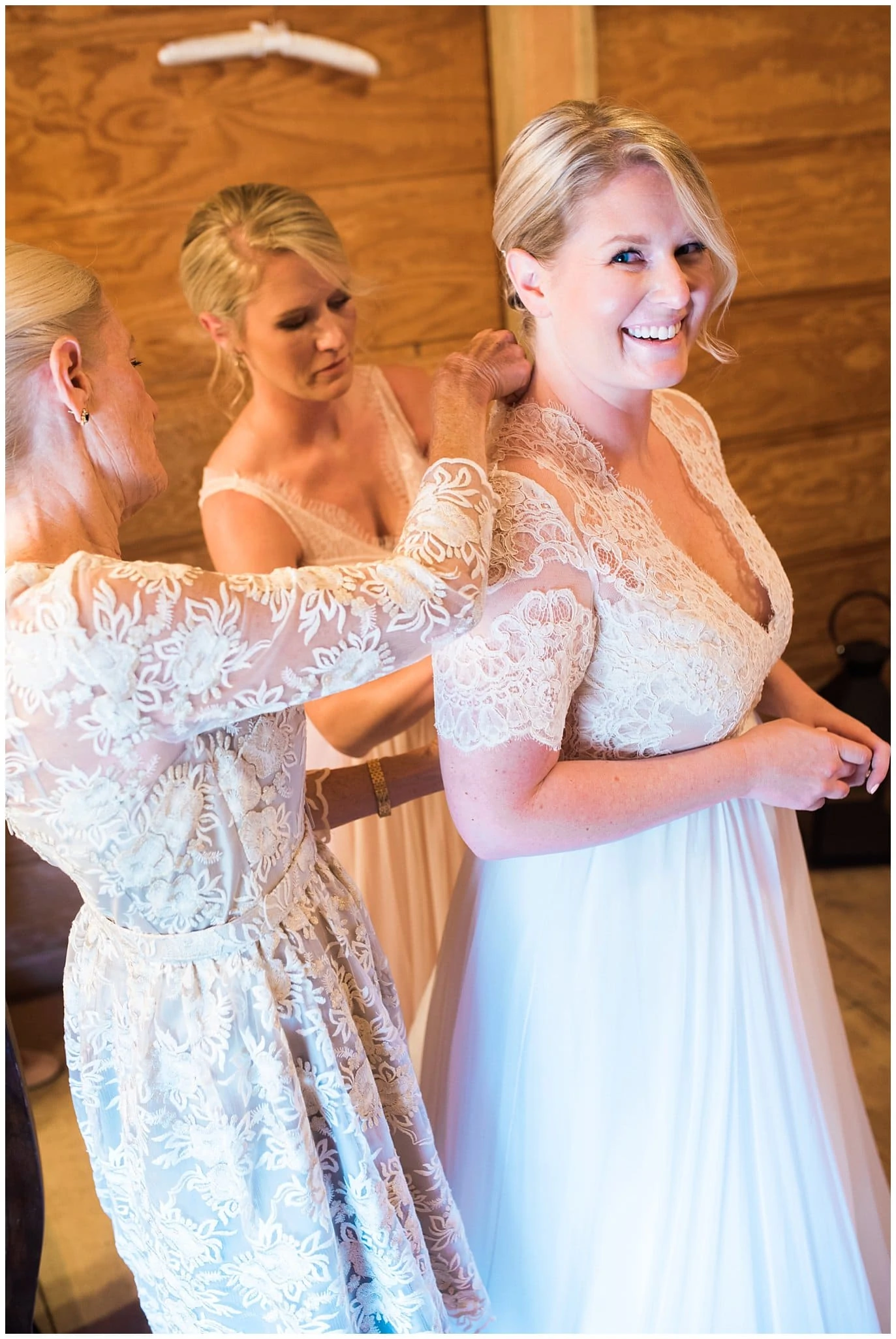 bride getting dressed with help of mother and sister at Piney River Ranch wedding by Vail Wedding photographer Jennie Crate, Photographer