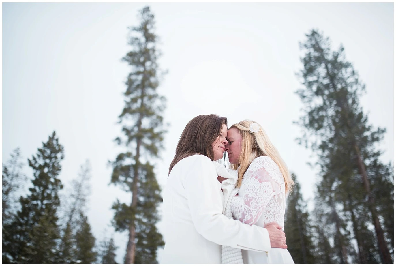 two brides cuddle in winter at devil's thumb ranch elopement by LGBTQ wedding photographer Jennie Crate