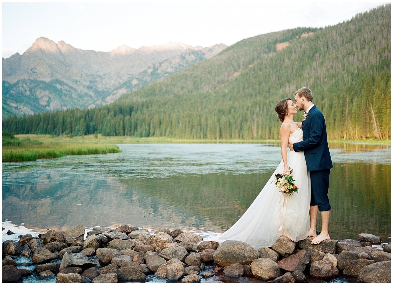 couple on rocks in front of lake and mountain at Piney River Ranch intimate wedding by Aspen wedding photographer Jennie Crate Photographer