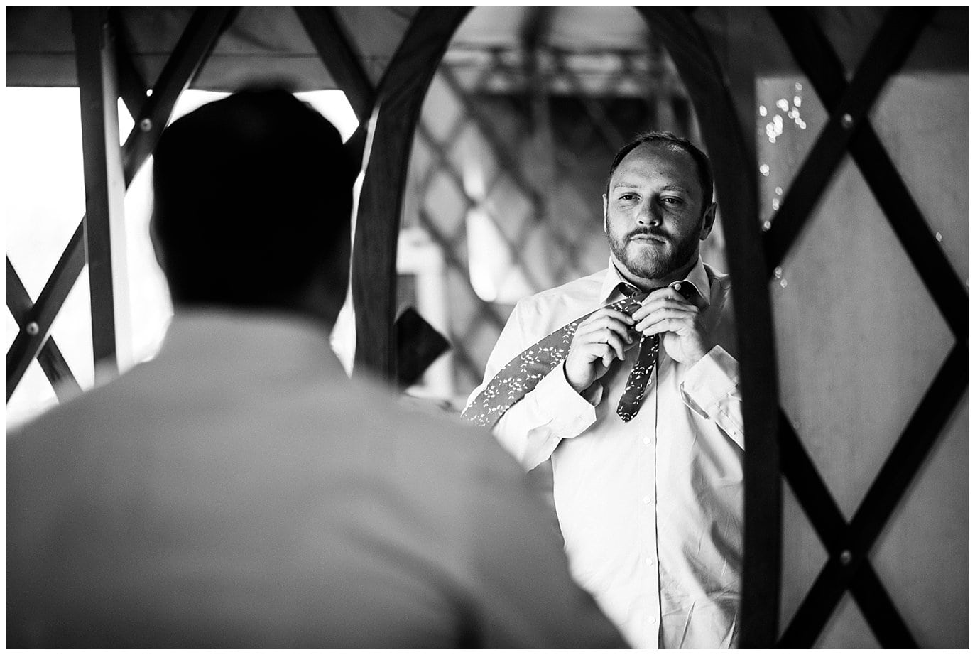 groom tying tie in mirror at Denver Botanic Gardens at Chatfield wedding by Boulder wedding photographer Jennie Crate photographer