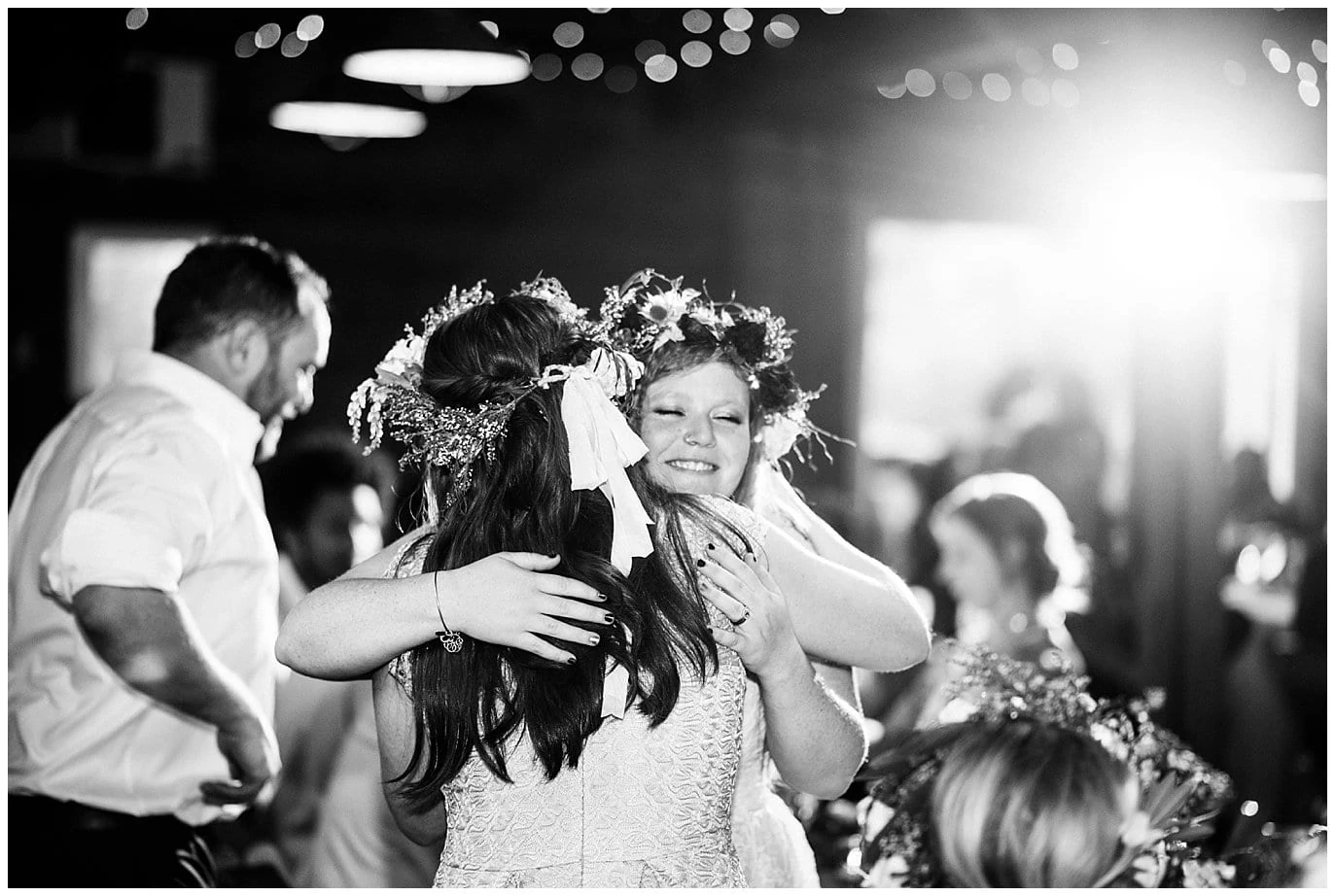 bride hugging maid of honor after wedding toast at Denver Botanic Gardens at Chatfield Summer Wedding by Chatfield Farms wedding photographer Jennie Crate photographer