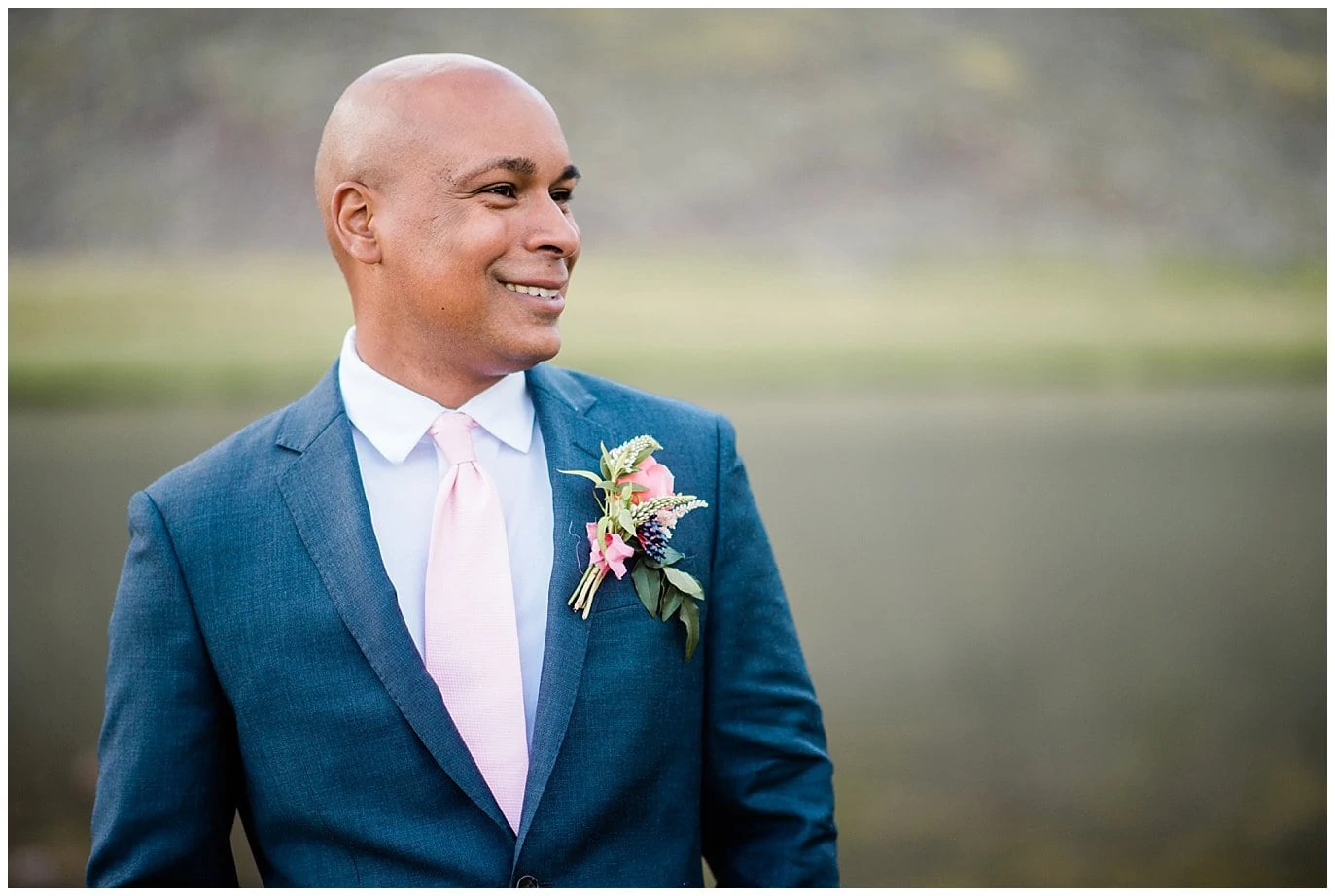 groom in blue suit with pink tie photo