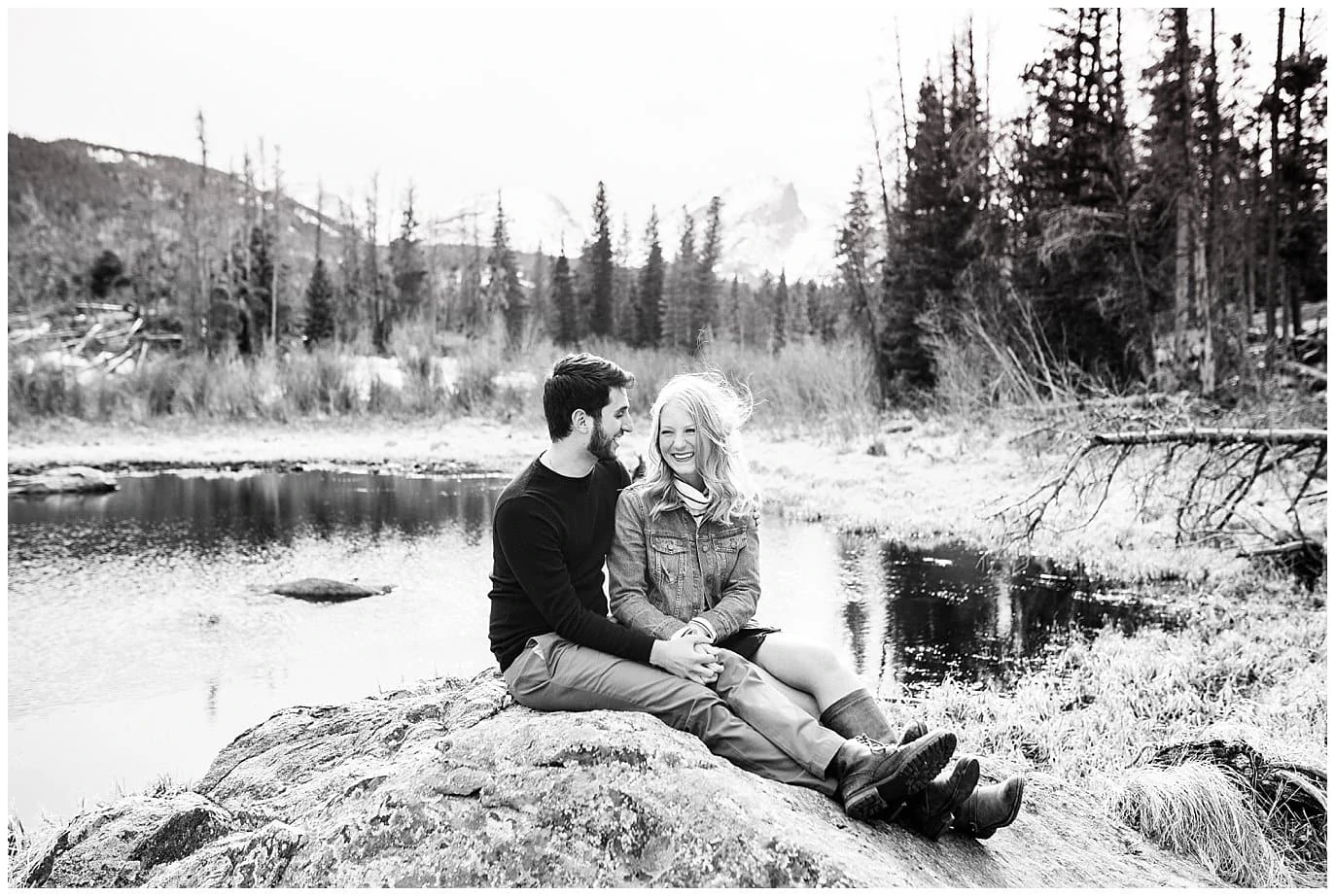 couple cuddles on rocks during spring Sprague Lake Engagement Photo