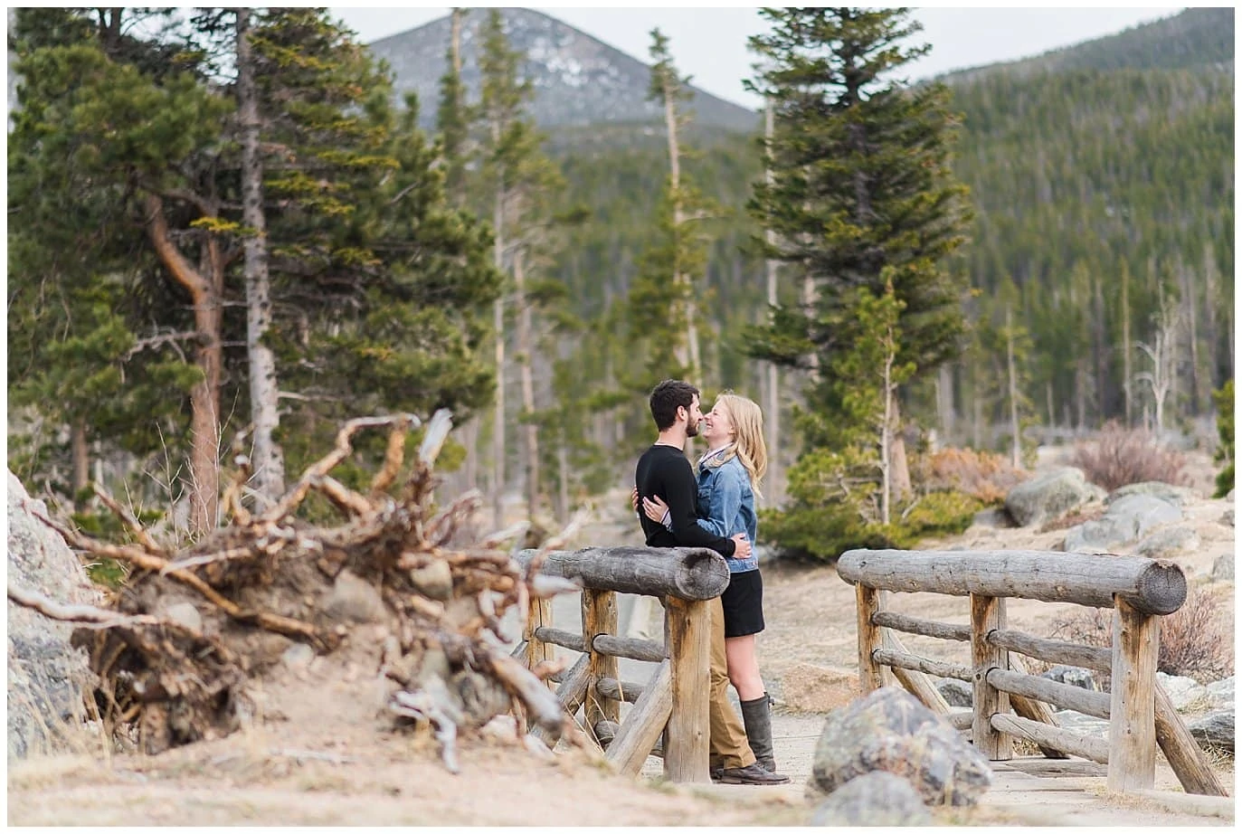 couple kisses on wooden bridge at Sprague Lake Engagement 