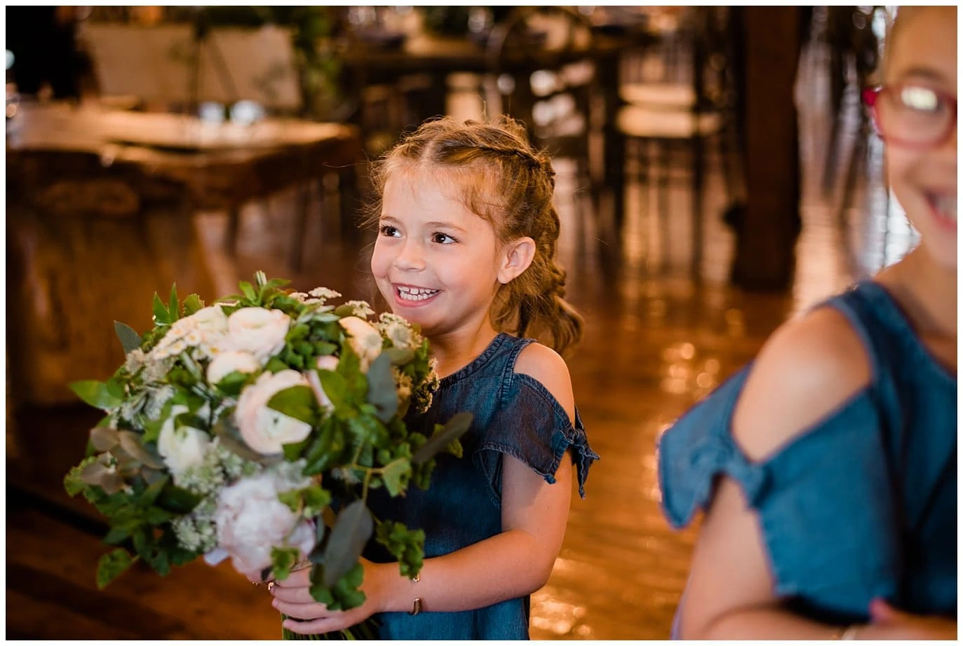 flower girl with bride's flower at Deer Creek Valley Ranch wedding by Denver Wedding Photographer Jennie Crate Photographer