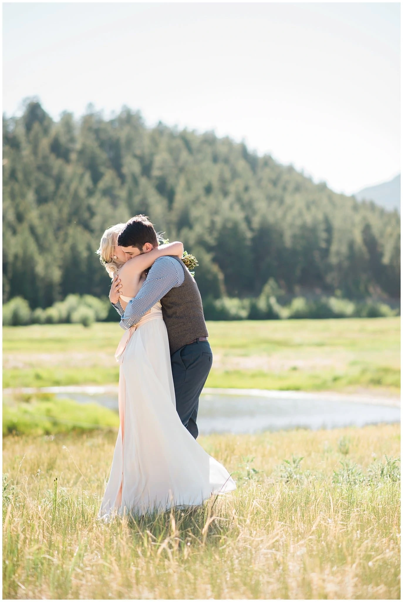 bride and groom in field after ceremony at Deer Creek Valley Ranch wedding by Conifer Wedding Photographer Jennie Crate Photographer