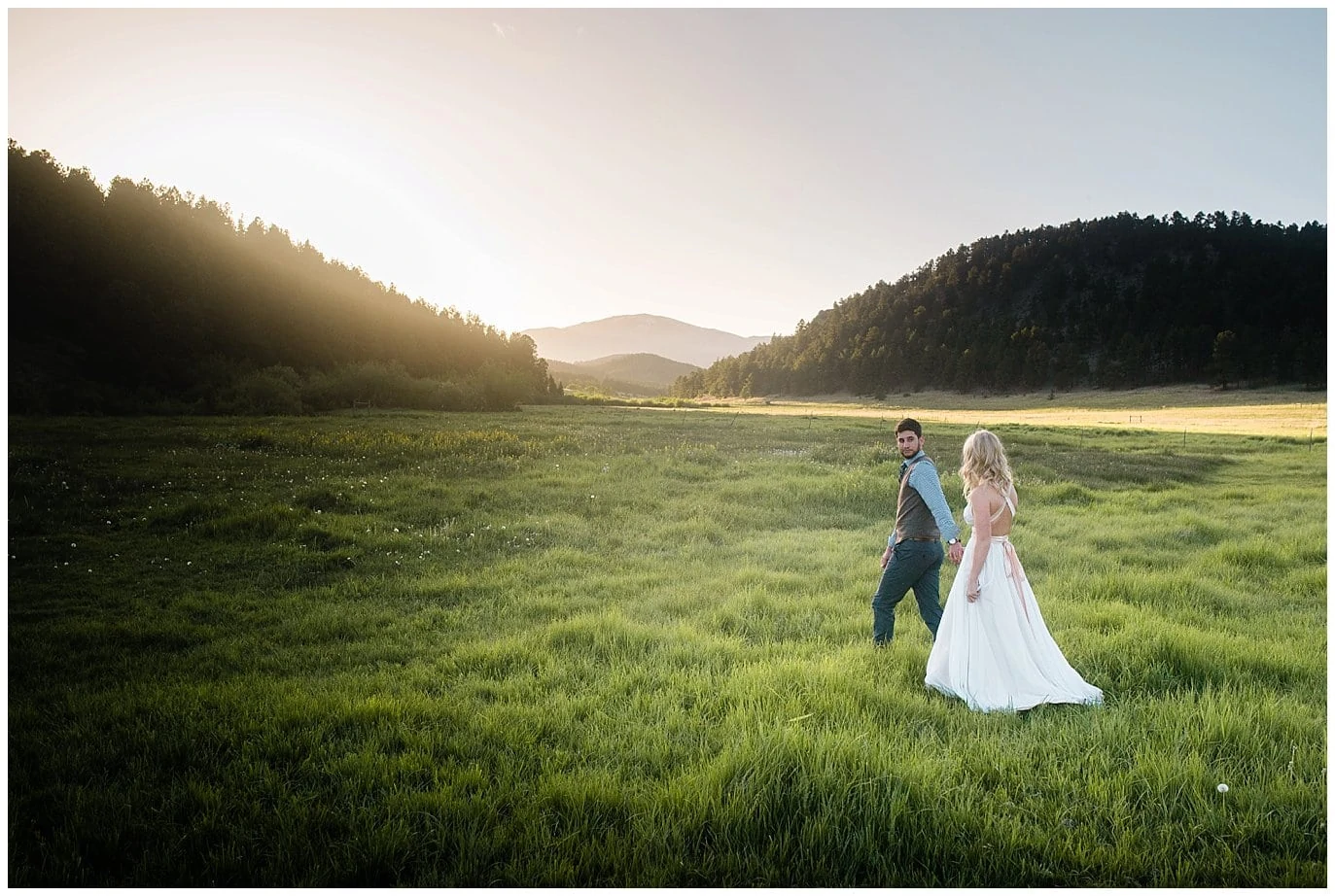 Bride and groom walk in fields at Deer Creek Valley Ranch wedding by Colorado Wedding Photographer Jennie Crate Photographer
