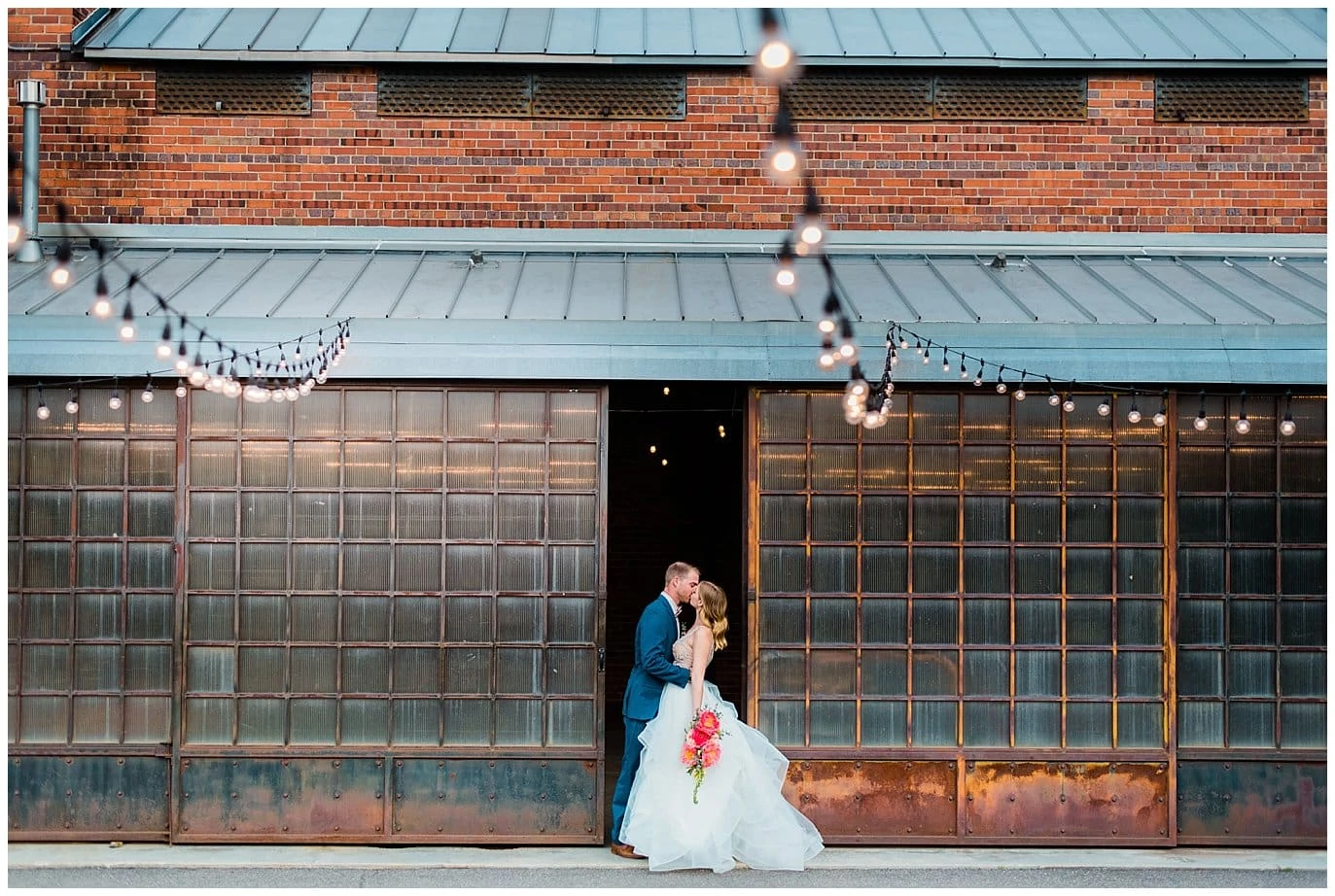 bride and groom under market lights in front of barn at blanc wedding by Denver wedding photographer Jennie Crate photographer