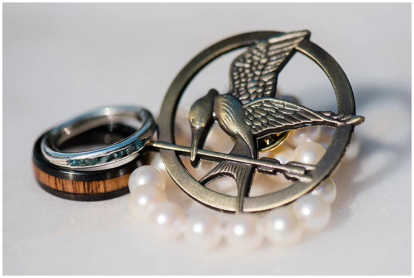 mockingjay pin and wedding rings photo