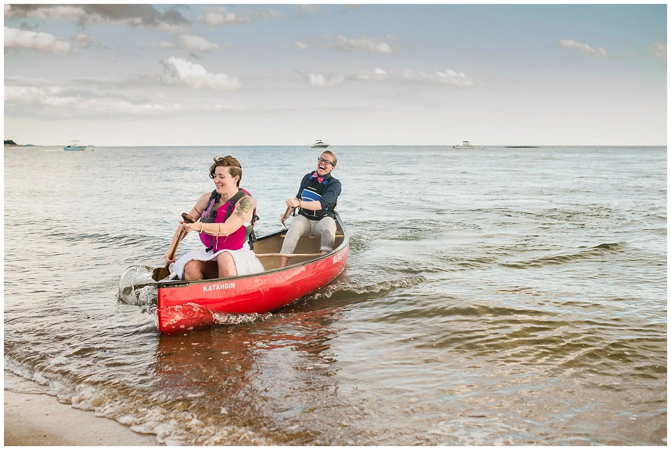 brides canoeing in ocean after ceremony photo
