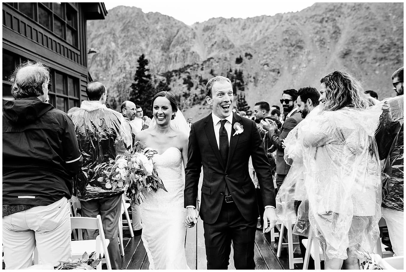 excited bride and groom walk down aisle at rainy Arapahoe Basin Black Mountain Lodge Wedding by Denver Wedding Photographer Jennie Crate