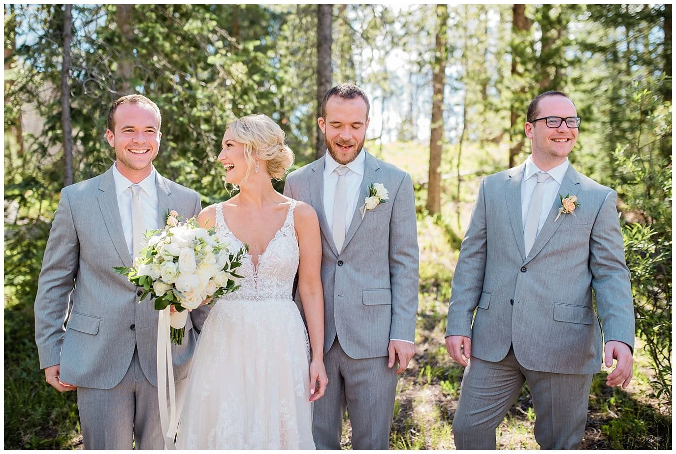 bride in lace dress with groomsmen in grey suits at Summer Piney River Ranch wedding by Vail wedding photographer Jennie Crate, Photographer