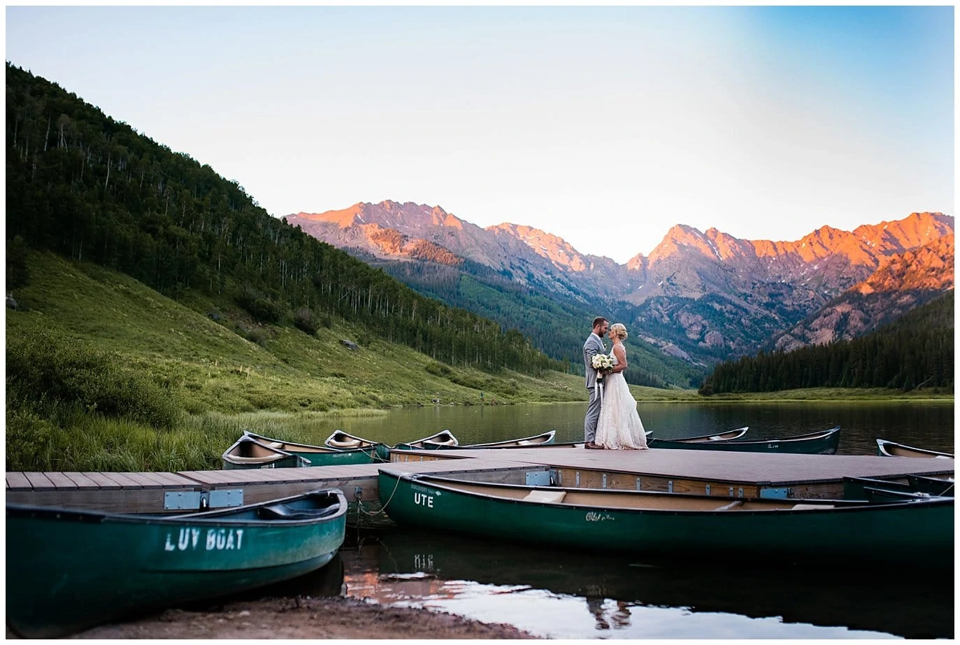couple at Colorado mountains on pier with canoes at Elegant Piney River Ranch wedding by Piney River Ranch wedding photographer Jennie Crate, Photographer