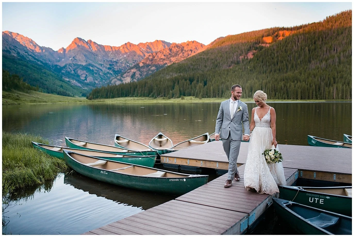 bride and groom walk on dock during sunset alpenglow at Piney River Ranch wedding by Vail wedding photographer Jennie Crate, Photographer