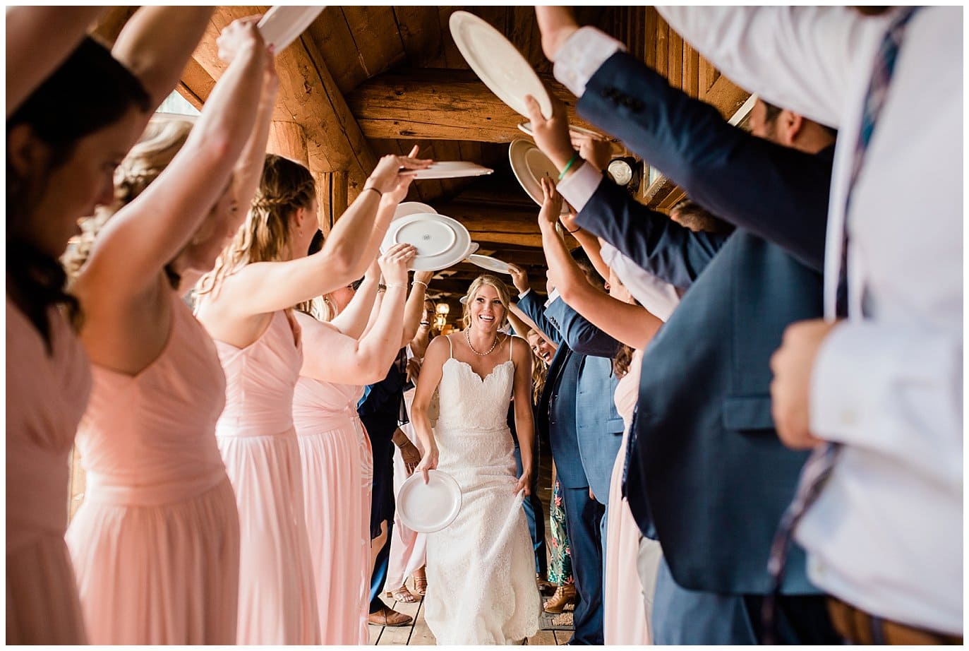 bride heading to buffet through tunnel of plates at Piney River Ranch Summer Wedding by Beaver Creek wedding photographer Jennie Crate photographer