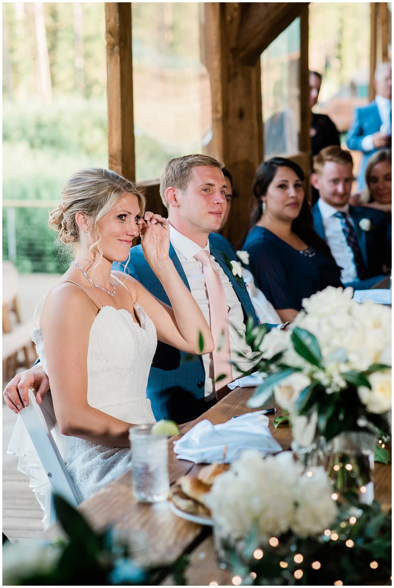 bride wipes away tears during emotional toasts at Piney River Ranch Summer Wedding by Beaver Creek wedding photographer Jennie Crate photographer
