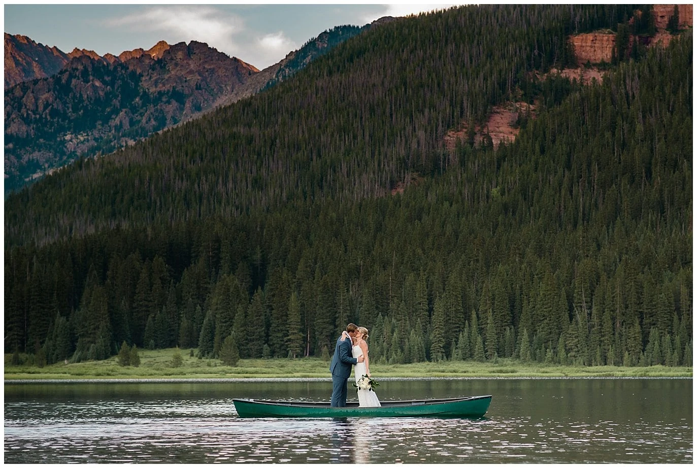 bride and groom standing in canoe on lake at Piney River Ranch wedding by Vail wedding photographer Jennie Crate photographer