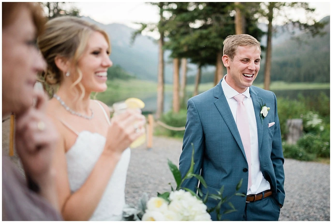 groom and bride sipping cocktails by lake at Piney River Ranch Summer Wedding by Avon wedding photographer Jennie Crate photographer
