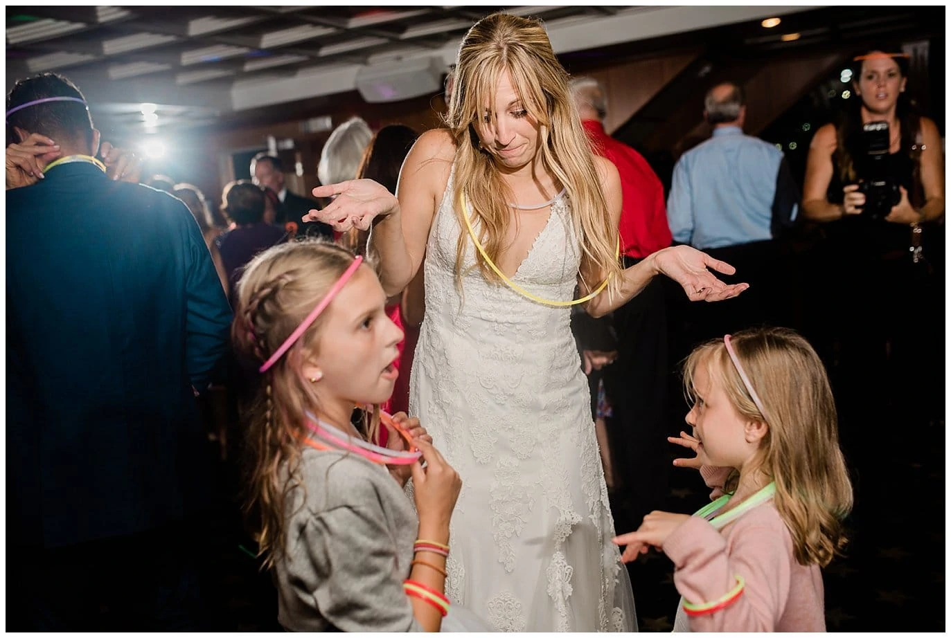 bride dancing with flower girls and glow sticks photo