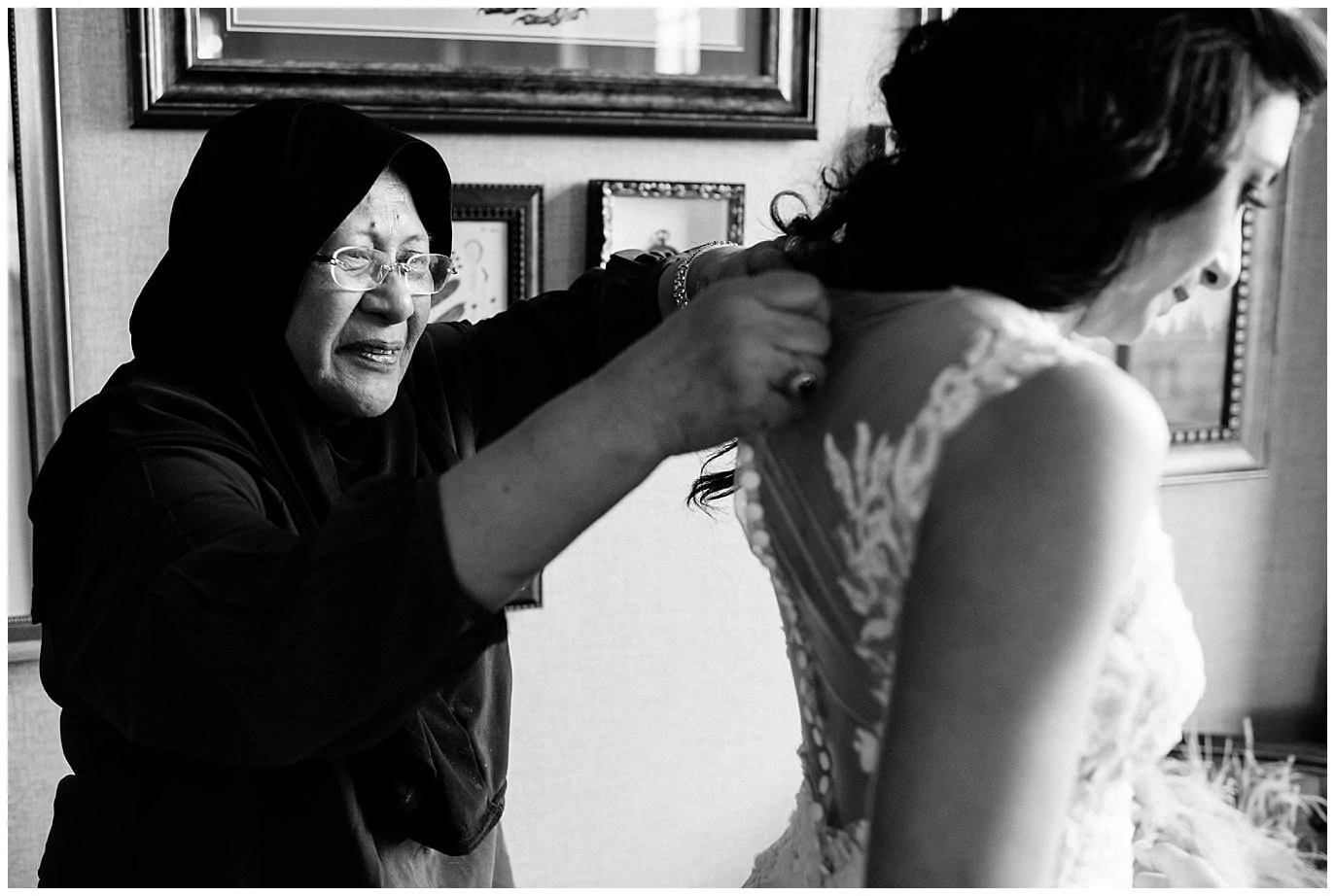 bride's mother helping her get dressed on wedding day by Blanc Wedding Photographer Jennie Crate