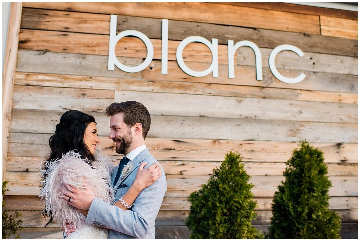 Bride and groom under blanc sign by Blanc Wedding Photographer Jennie Crate