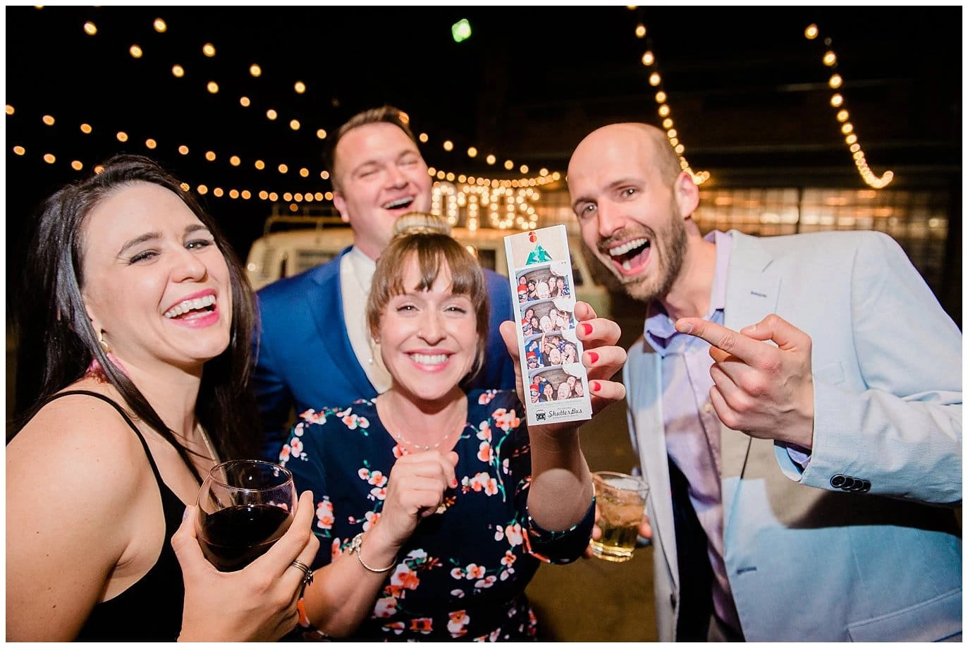guests laughing at photo booth photos at Blanc Wedding by Jennie Crate